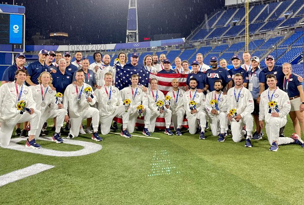 Team USA Baseball Team with silver medals around neck and holding American flag following medal ceremony at Olympics