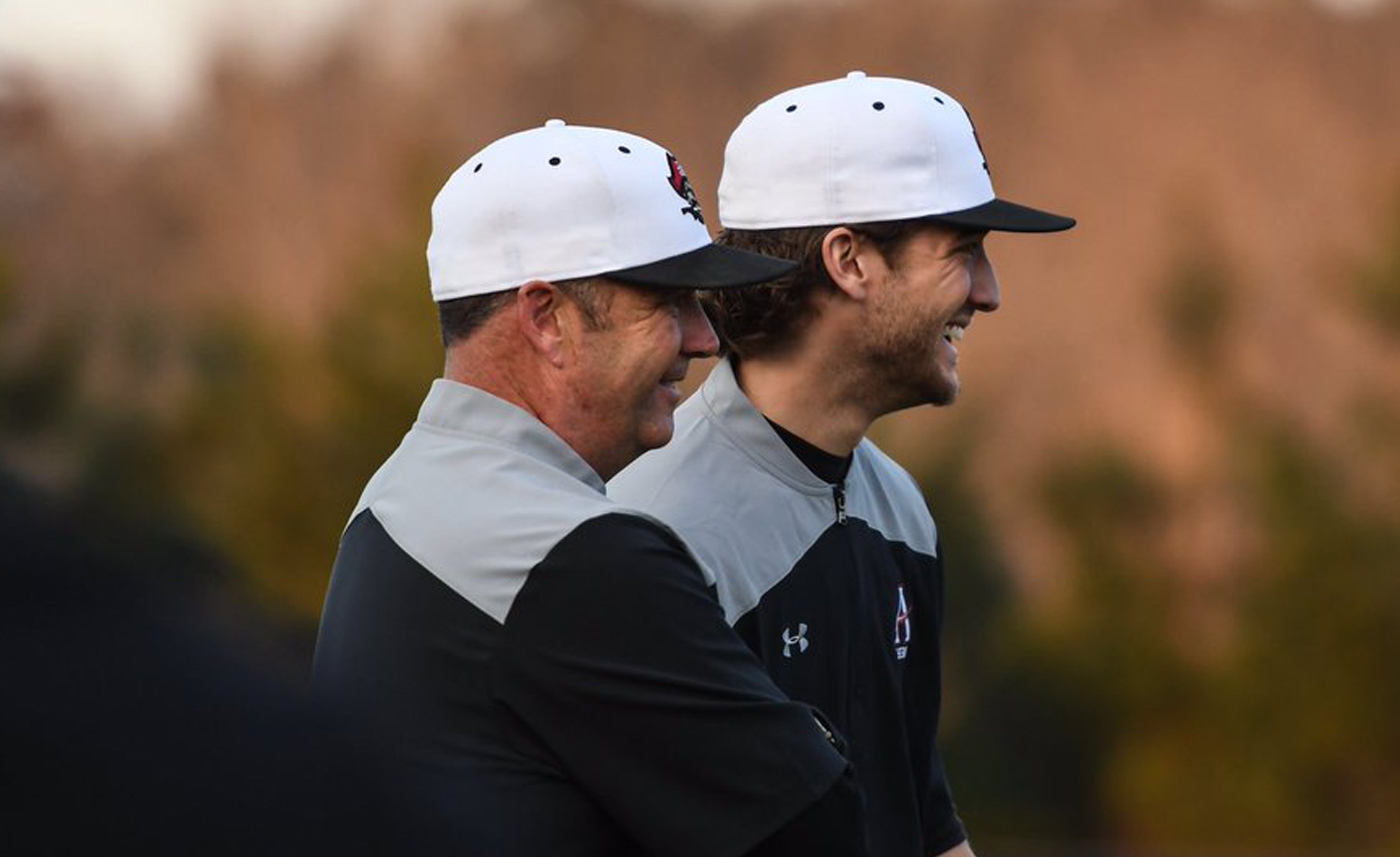 Mike Linch smiling while coaching player at Allatoona High