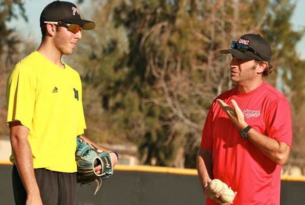 A coach talking to his player at practice on the field