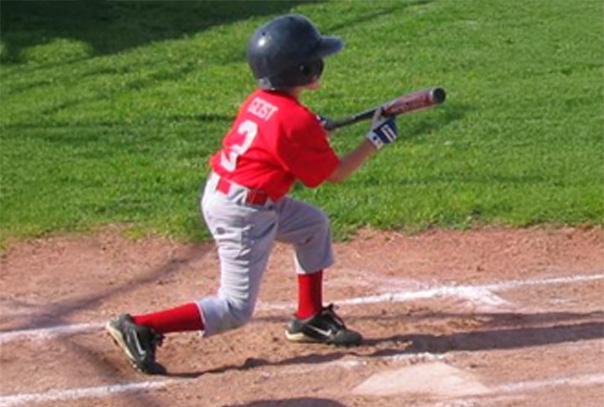 A youth baseball player in red jersey with #3 on back bunting the ball