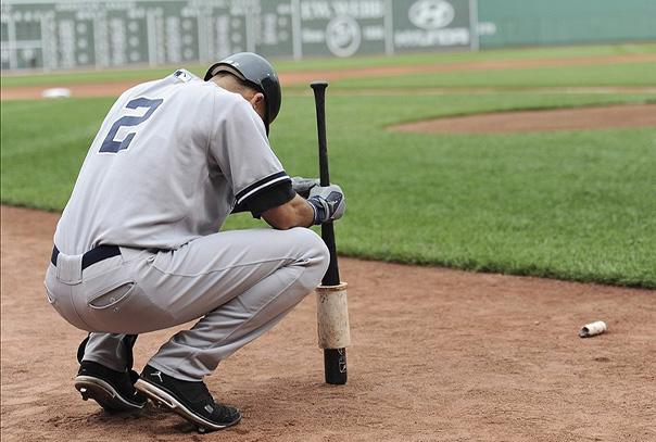 Derek Jeter bent down looking at ground focusing in on deck circle