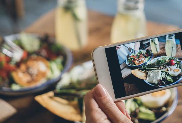 iPhone taking photo of a plate of food on table