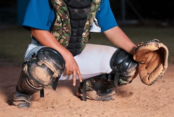 Catcher showing fingers between legs as signal